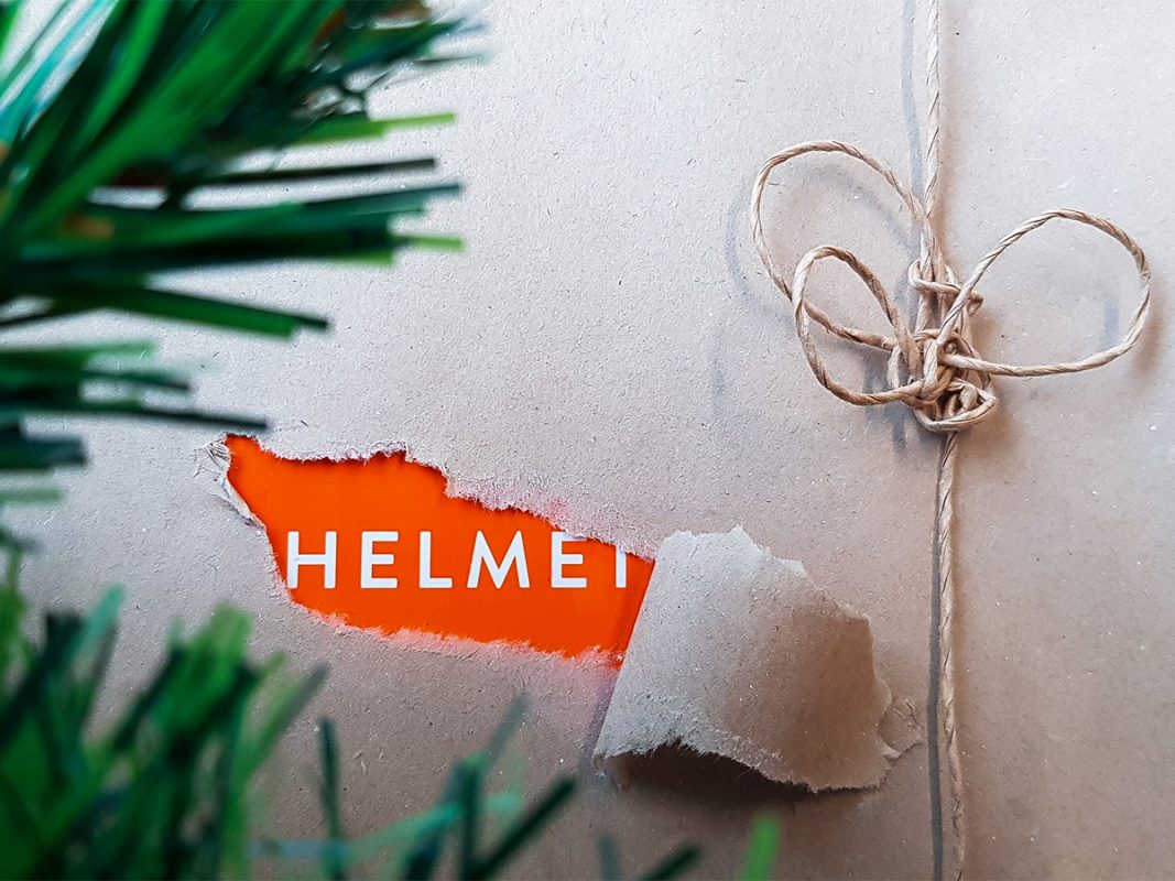 Joulupaketti, jonka käärettä on hiukan revitty. Repeämän alta paljastuu Helmet-teksti.